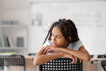 Sad African-American girl at school. Stop racism