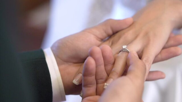 Groom wearing a ring for the bride