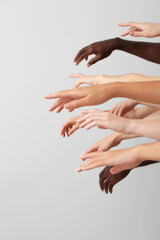 Hands of Caucasian women and African-American man on grey background. Racism concept
