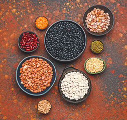 Different raw legumes on color background