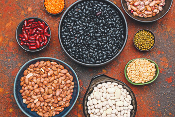Different raw legumes on color background