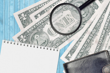 1 US dollar bills and magnifying glass with black purse and notepad. Concept of counterfeit money....