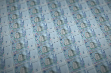 5 Ukrainian hryvnias bills printed in illegal money production conveyor. Collage of many fake...