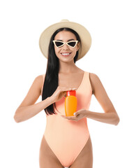 Happy young woman with sun protection cream on white background