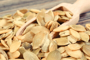 Heap of pumpkin with spoon on wooden board. Healthy food containing dietary fiber