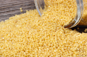 Millet groats containing minerals and fiber. Wooden background