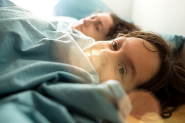 Obraz na płótnie Canvas Sleepy child lies in bed with mother.