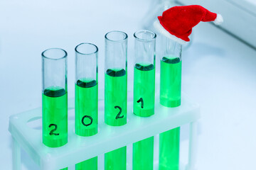 five vials of green solution in a chemical lab. on the end tube is a miniature decorative red cap