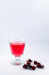 A cup of pink rosella tea with dried rosella
