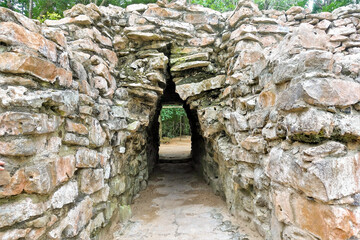 The fortress wall of the ancient Mayan city of Tulum. A very thick protective wall is made of large stones. The passage to the city is low and narrow. Good defense against enemies. Mexico.