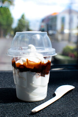 soft serve chocolate ice-cream sundae, sweets in a plastic cup with a plastic spoon from a...