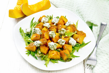 Salad of pumpkin and cheese in plate on white board