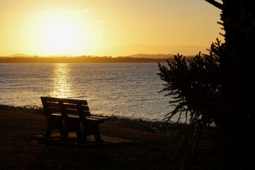 Fototapeta na wymiar Empty seat silhouetted against golden sunset.