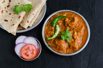 Dum Ka Murgh or Lagan Ka Murgh tikka slow cooked chicken hot and spicy curry dish and roti Hyderabad, India. Popular South Indian non-vegetarian cuisine prepared using yogurt, tomato, Garam Masala. 