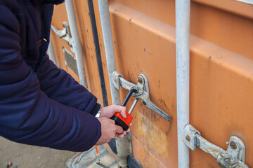 The man opens the lock. Man closes the lock. Container.
