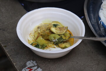 Rice noodle in green curry in a white foam bowl