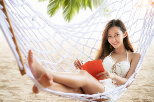 Asian girl sleep and reading on the beach thid image can use for travel, summer