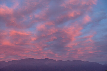 Panorama of amazing purple cloudy sunset sky over Los Andes mountains