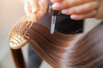 Close-up drop of oil restore and recovery hair is applied to head bulbs. Concept hairdresser spa salon