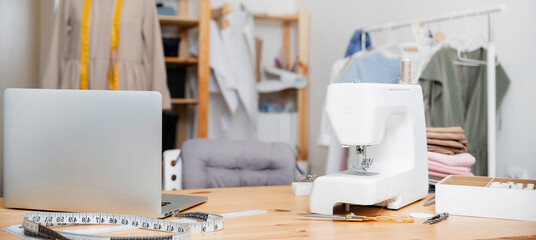 Workplace of seamstress, fashion designer for sew clothes, laptop, sewing machine, mannequin