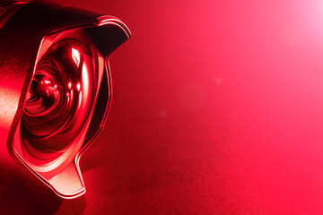 The camera lens with red  backlight. Close-up of the camera lens on a red  background. Optics..