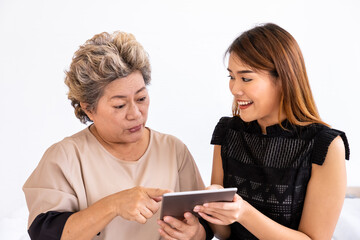 Happy senior elderly Asian woman female mother and daughter enjoy online shopping using digital tablet