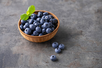 Fresh ripe blueberries in basket on dark background.
