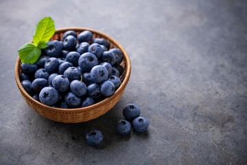 Fresh ripe blueberries in basket on dark background.
