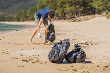Man in gloves pick up plastic bags that pollute sea. Problem of spilled rubbish trash garbage on the beach sand caused by man-made pollution and environmental, campaign to clean volunteer in concept
