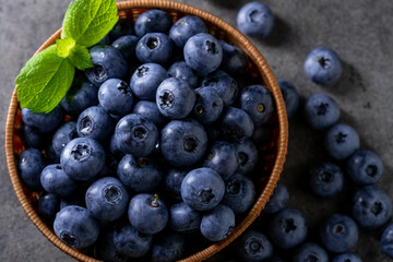 Fresh ripe blueberries in basket on dark background.
