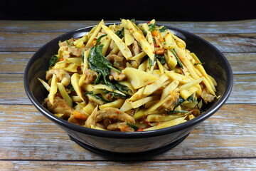 Stirred and fried sliced pickled bamboo shoot with chilly, cutting chicken, basil and red curry...