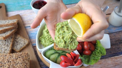 Squeezing Lemon On Avocado Toast In Hand.