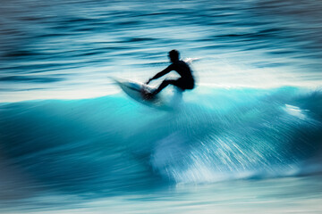 motion blur of a surfer riding the wave on a blue ocean during the summer season.
