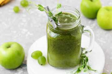 Green vitamin smoothie with shoots of young peas. Green smoothie made from apple, grape and kiwi
