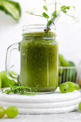 Green vitamin smoothie with shoots of young peas. Green smoothie made from apple, grape and kiwi
