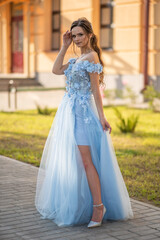 Russian graduates posing in a beautiful dress against the backdrop of their school.