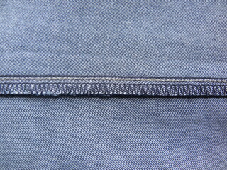 Overlocking stitch on light blue color jeans