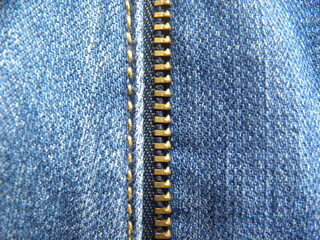 Interlocking metal teeth of zipper of blue color jeans