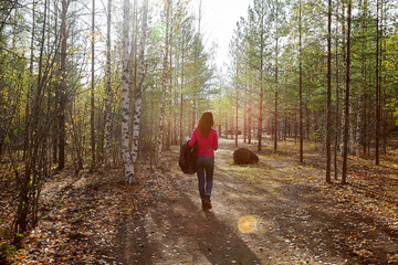 Beautiful young woman walking in the forest with sprice in autumn