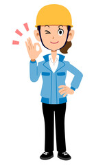 OKのサインを出すヘルメットを被った青い作業着の女性
