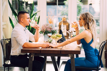 romantic dinner for couple. lovers drink wine from glasses.