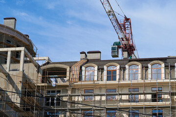 Fototapeta na wymiar modern building under construction, plastered walls and scaffolding, construction crane