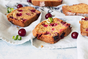 Pieces of nut cake with cherry over linen napkin, light concrete background. Homemade fresh bakery for desert.