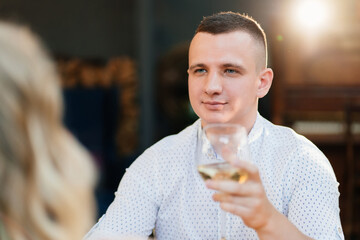man. romantic dinner for couple. lovers drink wine from glasses.