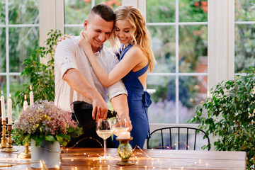 love happy couple on romantic dinner with glass. guy pours champagne.