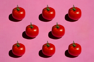 Tomato isolated on pink background. Still life photography.