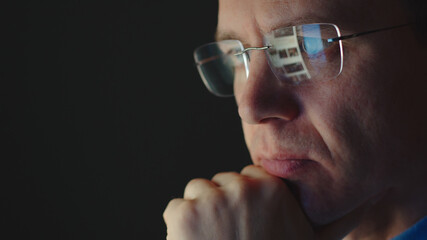 REFLECTION: Face of adult businessman in an eyeglasses looking a website - 365153782