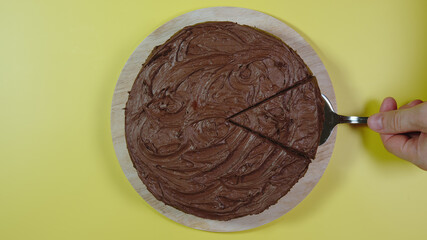 TOP VIEW: Chocolate cake without one piece on yellow surface
