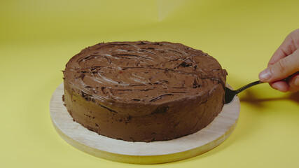 Male hand picks up piece of chocolate cake