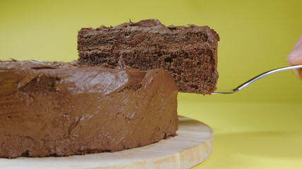 SIDE VIEW: Male hand picks up piece of chocolate cake